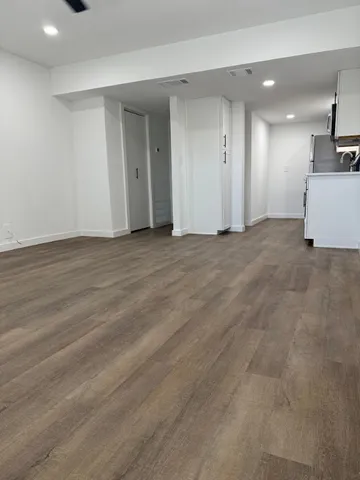 an empty room with wooden floor and white walls