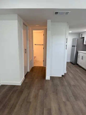 a view of a room with wooden floor and a window