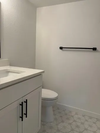 a bathroom with a sink a toilet and a mirror