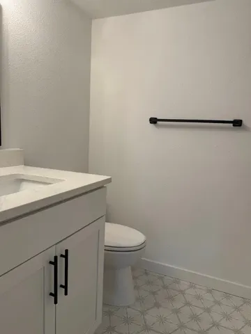 a bathroom with a sink a toilet and a mirror