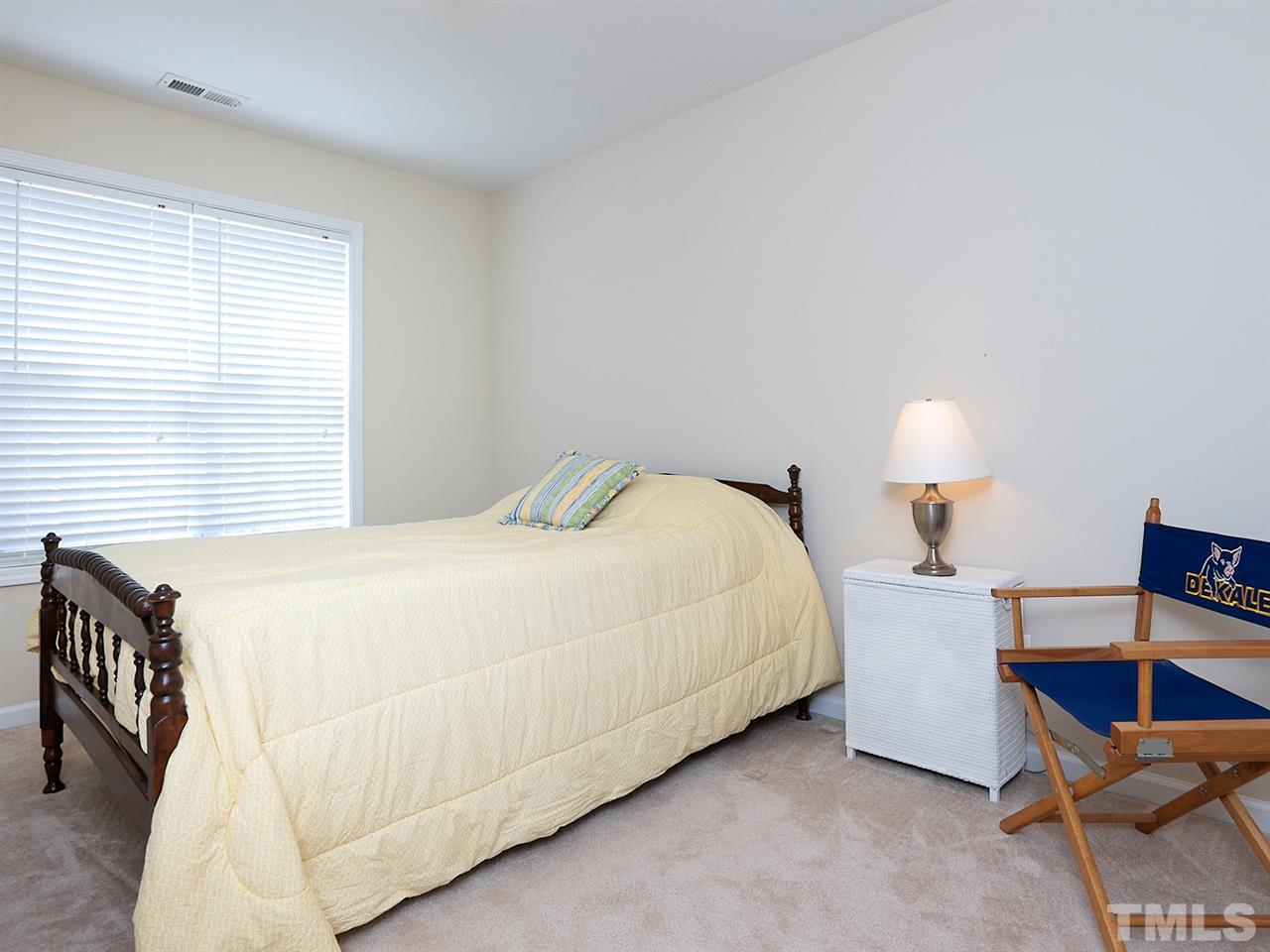 2708 Andover Glen Road Raleigh, NC 27604 - Photo 16 of 25 a bedroom with a bed and a lamp on table