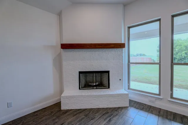 a living room with a fireplace and windows