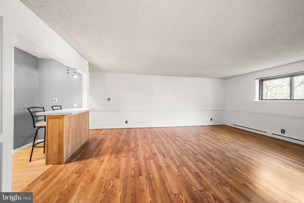 an empty room with wooden floor and window