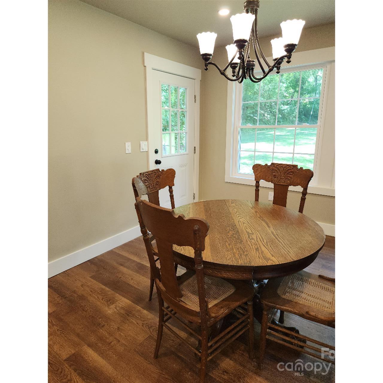 283 Robin Drive Marion, NC 28752 - Photo 12 of 30 a dining room with furniture a large window and a chandelier