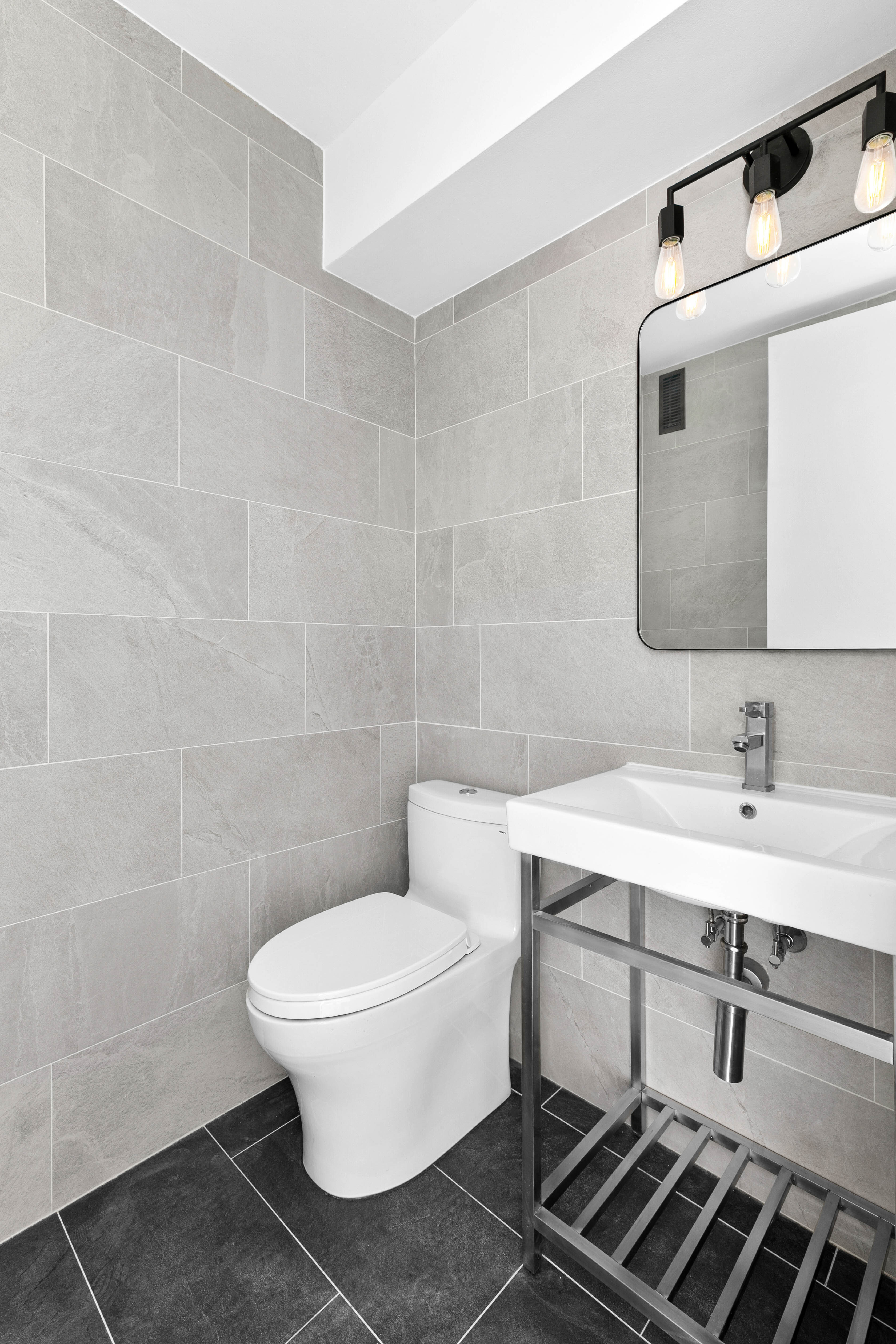 235 East 40th Street, Unit 26G Manhattan, NY 10016 - Photo 4 of 7 a bathroom with a toilet a sink and mirror