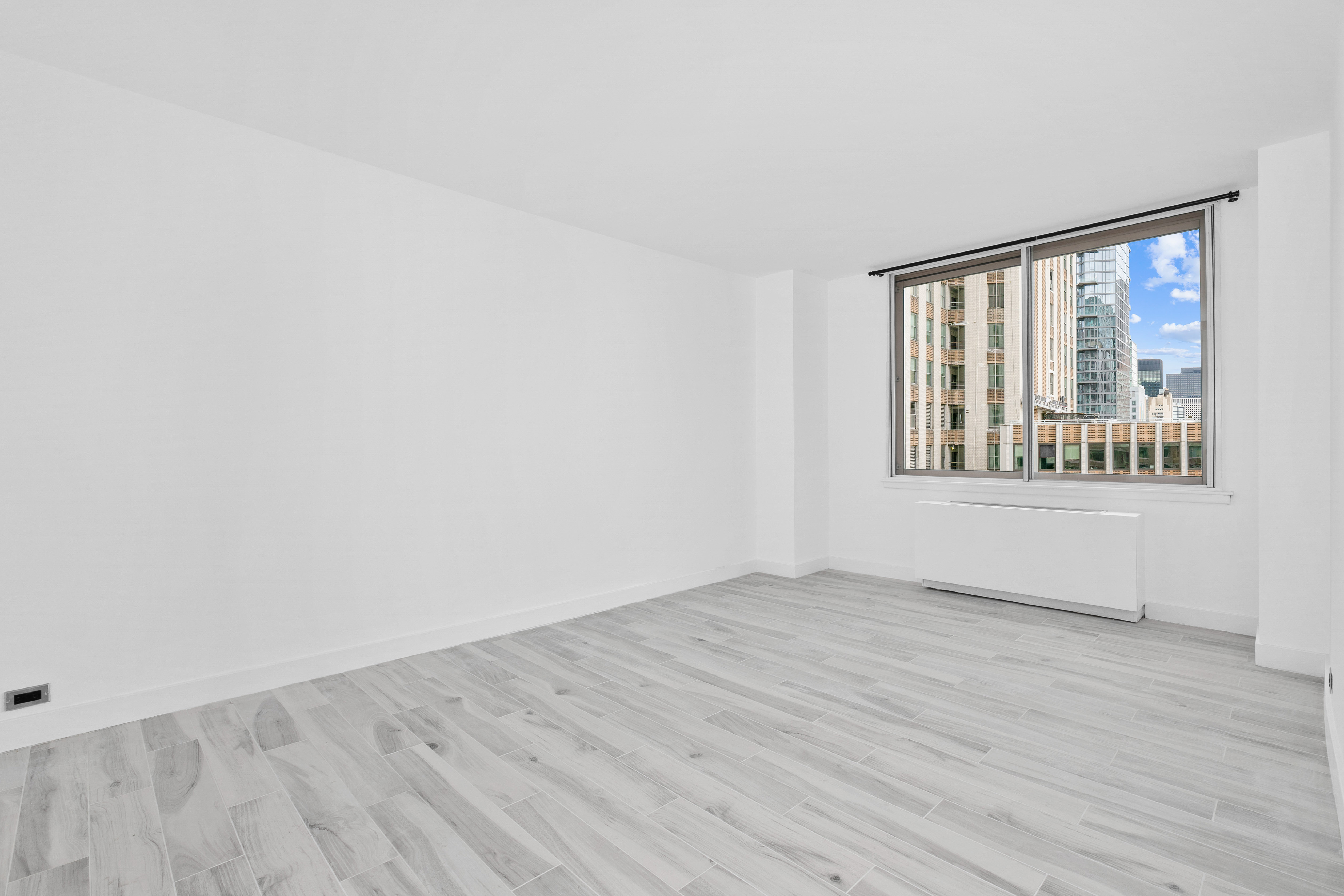 235 East 40th Street, Unit 26G Manhattan, NY 10016 - Photo 5 of 7 an empty room with wooden floor and windows