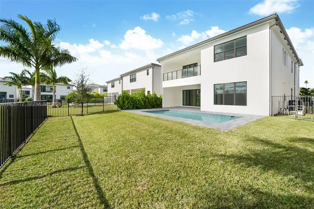 a view of a living room a kitchen with stainless steel appliances