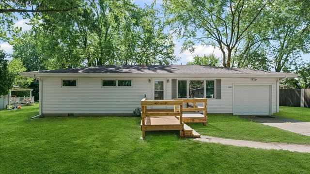 a view of a house with a yard and sitting area