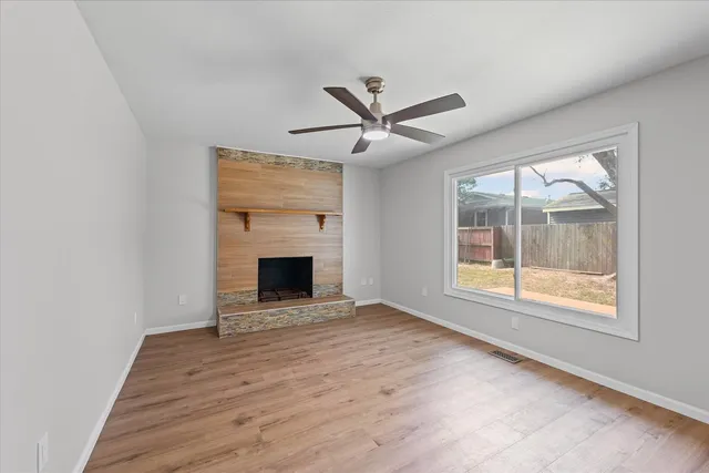 an empty room with windows and a fireplace