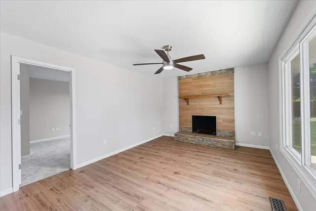 wooden floor fireplace and windows in an empty room