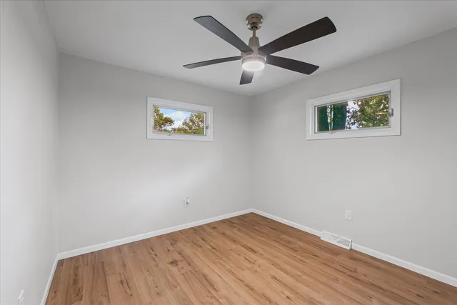 a view of empty room with wooden floor