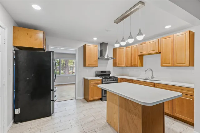 a kitchen with a sink a stove a refrigerator and a cabinets