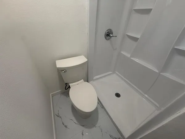 a bathroom with a toilet and a shower