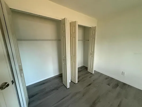 an empty room with wooden floor and entrance