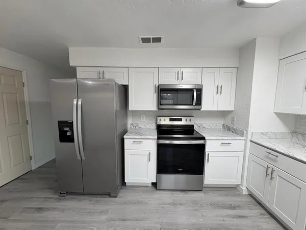 a kitchen with a refrigerator stove and microwave