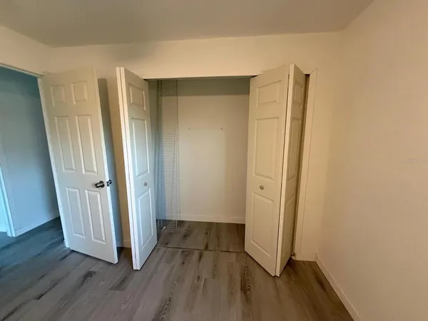 an empty room with wooden floor and a window