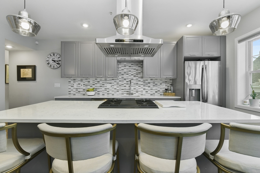 47 Sargent Street, Unit 3 Boston, MA 02125 - Photo 6 of 21 a kitchen with stainless steel appliances wooden floor dining table and chairs