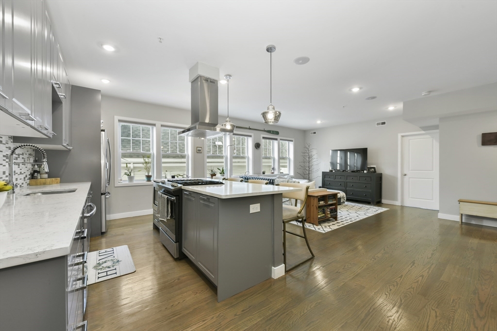 47 Sargent Street, Unit 3 Boston, MA 02125 - Photo 8 of 21 a kitchen with stainless steel appliances granite countertop a sink a stove and a wooden floors