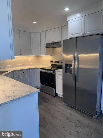 a kitchen with stainless steel appliances granite countertop a refrigerator a sink and a stove