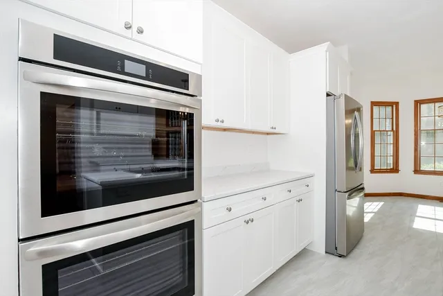a kitchen with windows and white cabinets