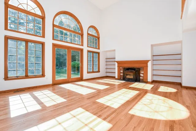 a view of an empty room with a window and a fireplace