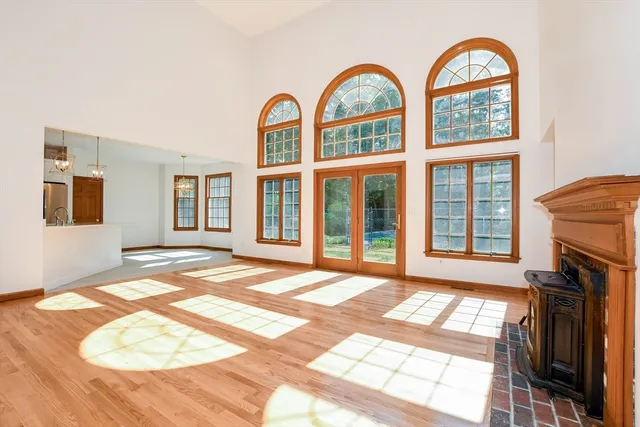 a view of a livingroom with wooden floor and a fireplace
