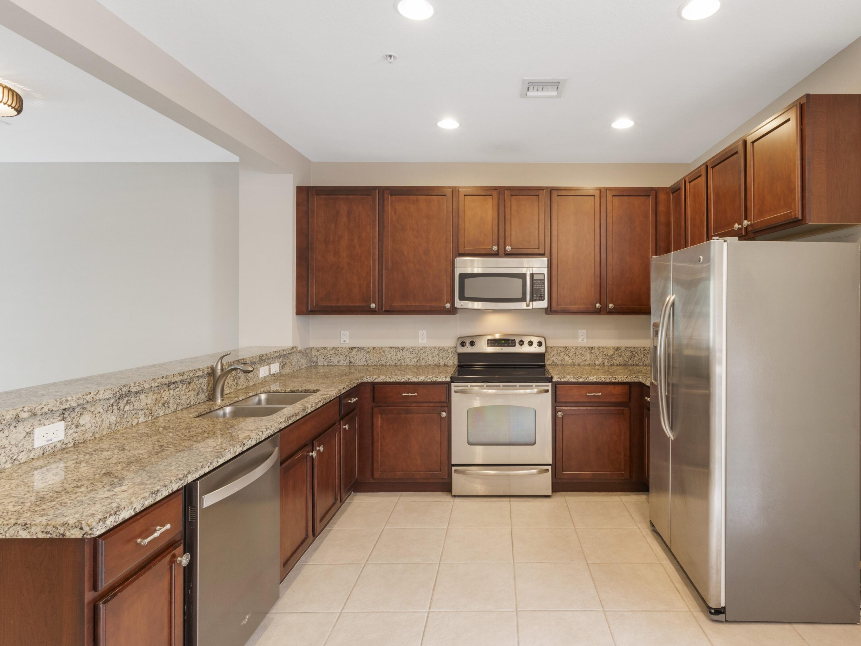 110 West Coda Circle, Unit 110 Delray Beach, FL 33444 - Photo 11 of 42 a kitchen with granite countertop stainless steel appliances and cabinets