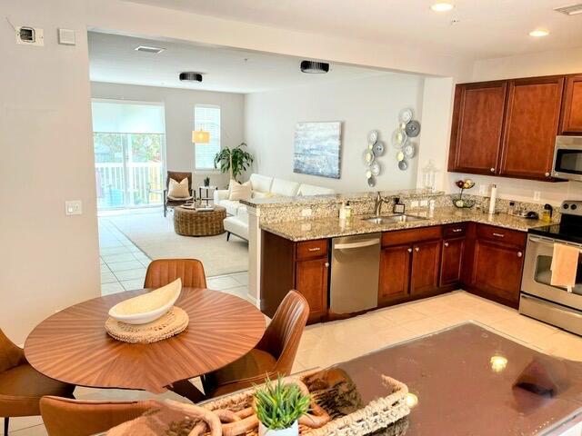 110 West Coda Circle, Unit 110 Delray Beach, FL 33444 - Photo 14 of 42 a kitchen with a sink a stove and chairs
