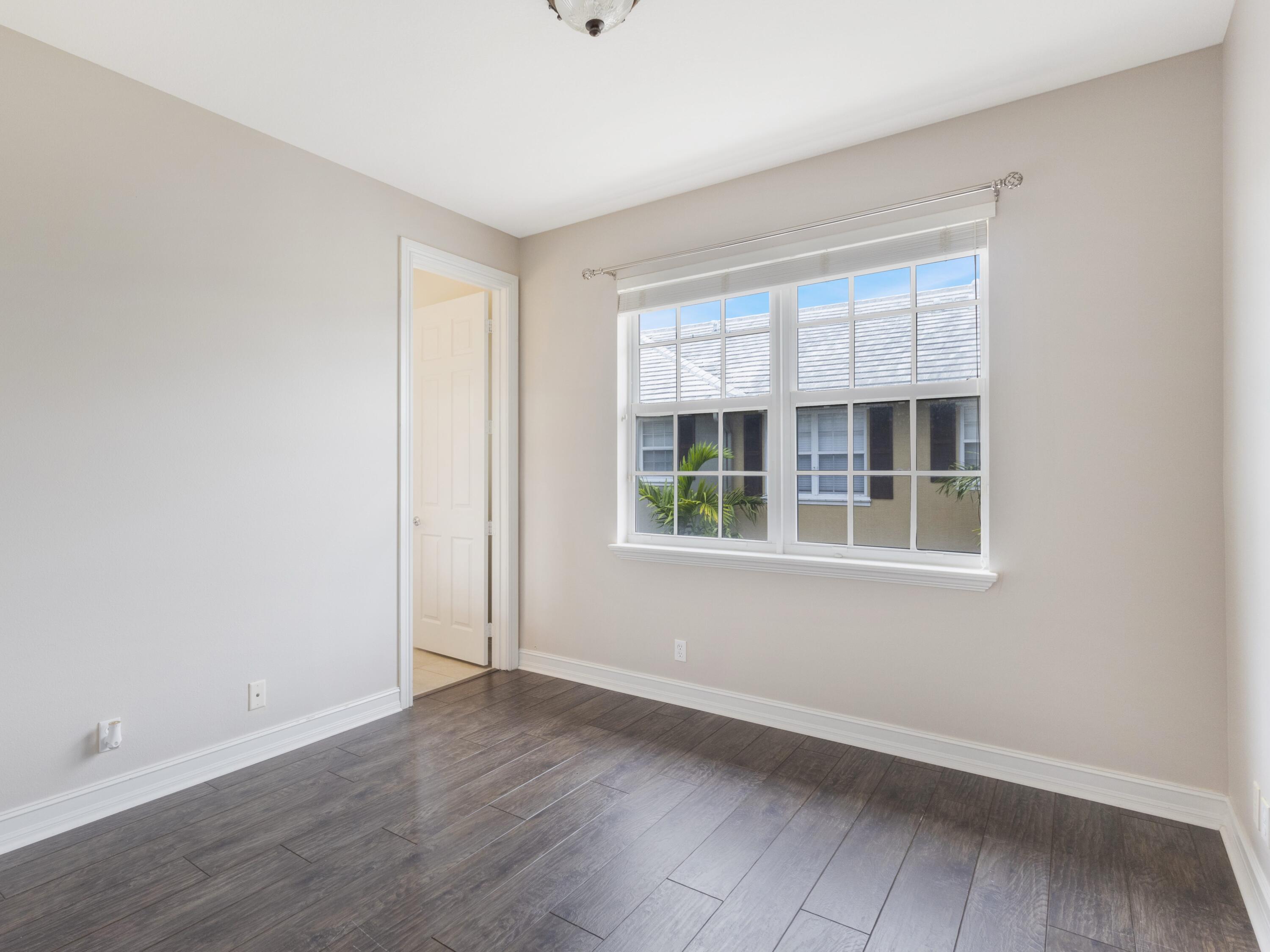 110 West Coda Circle, Unit 110 Delray Beach, FL 33444 - Photo 23 of 42 an empty room with wooden floor and windows