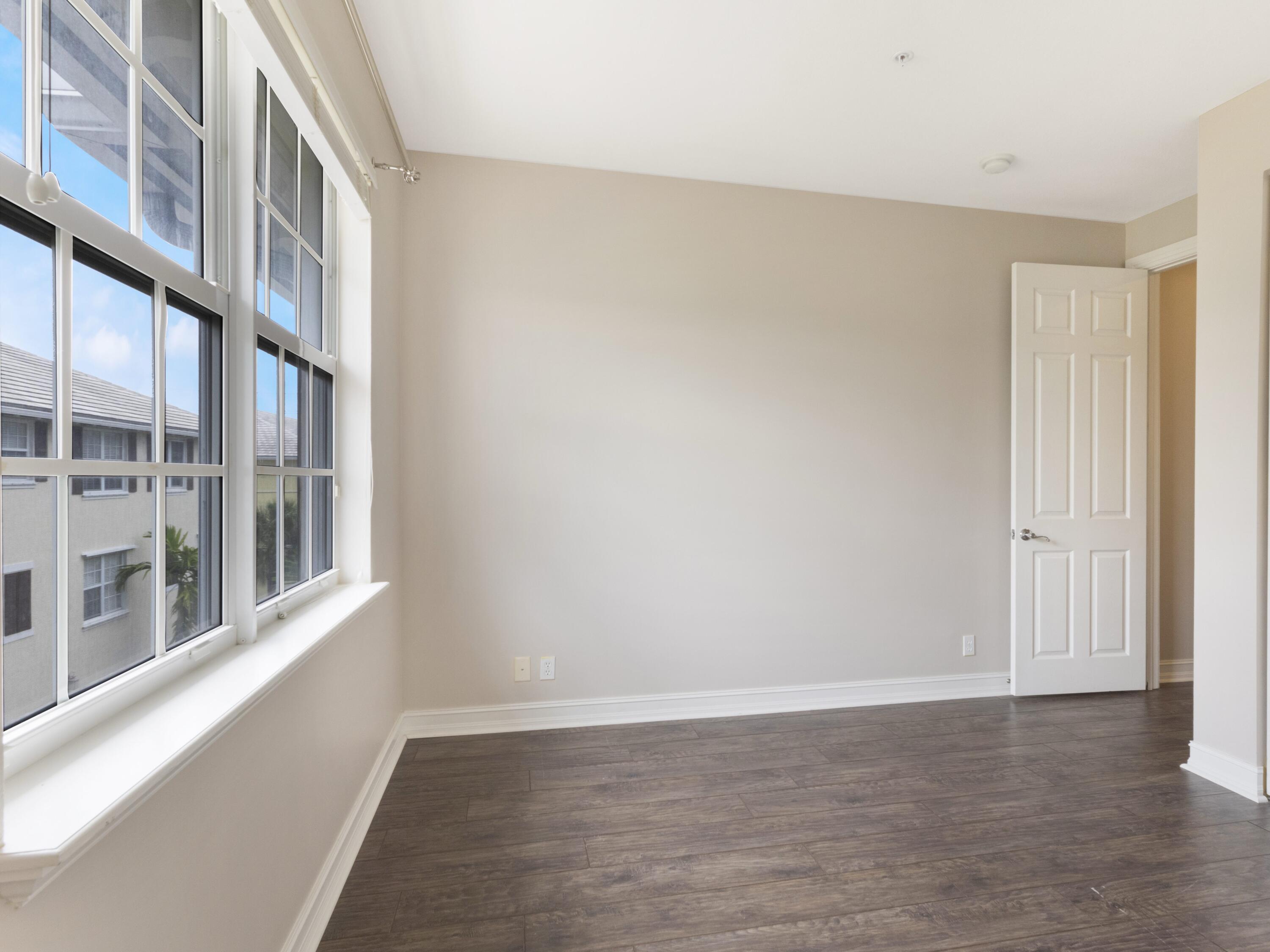 110 West Coda Circle, Unit 110 Delray Beach, FL 33444 - Photo 24 of 42 an empty room with wooden floor and windows