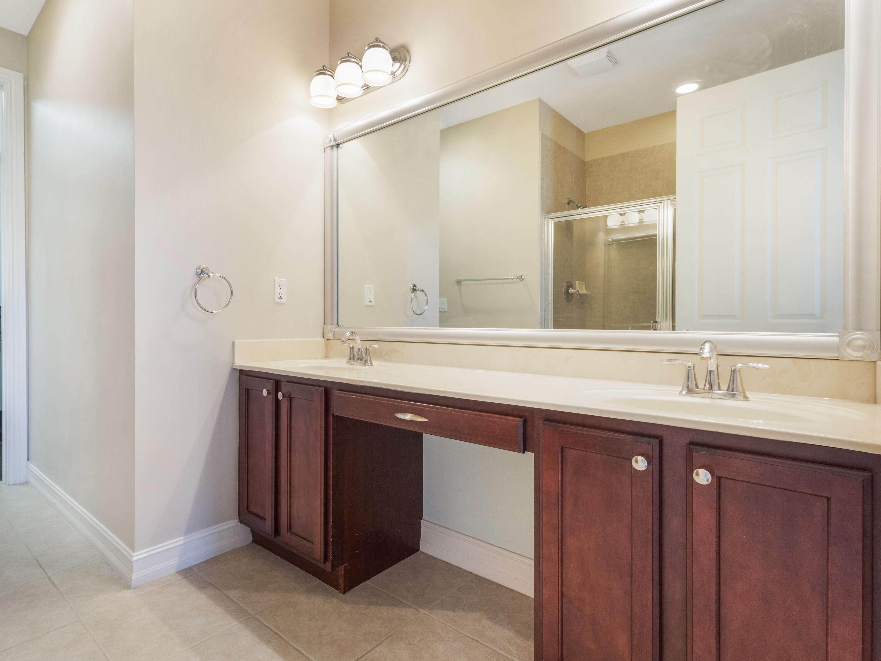 110 West Coda Circle, Unit 110 Delray Beach, FL 33444 - Photo 32 of 42 a bathroom with a double vanity sink and a mirror