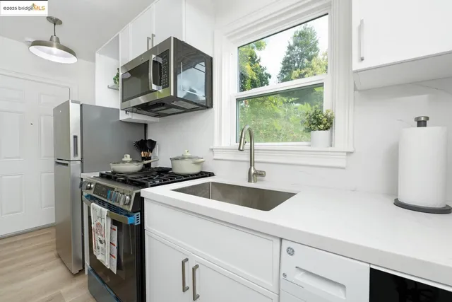 a kitchen with stainless steel appliances granite countertop a sink a stove and a refrigerator