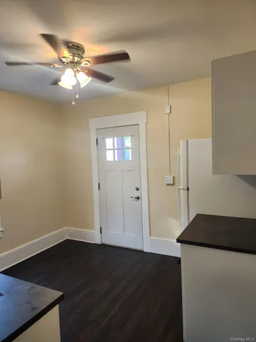 a view of a livingroom with a chandelier fan and wooden floor