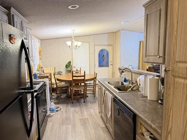 a kitchen with sink refrigerator and table
