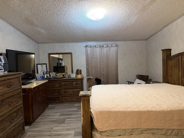 a large bedroom with a bed and a flat screen tv