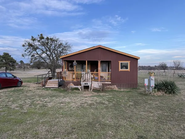 a view of a house with a yard and sitting area