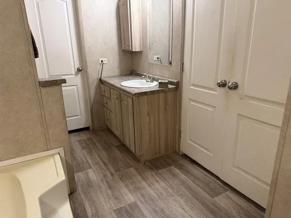 a view of a bathroom with a sink and wooden floor