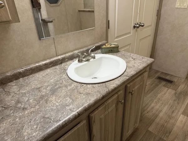 a bathroom with a granite countertop sink and a mirror