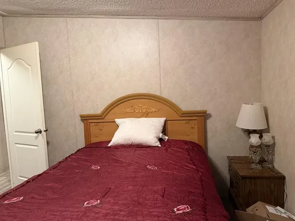 a bedroom with a bed and a lamp on the table