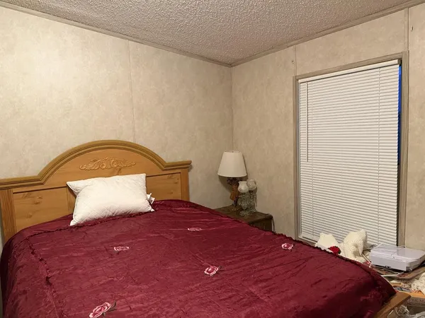 a bedroom with a bed and a lamp on table