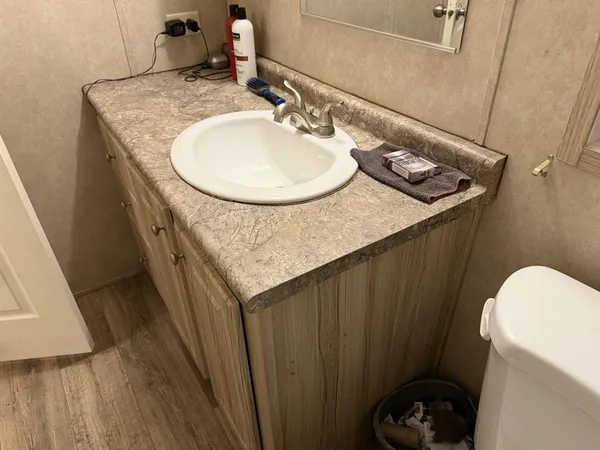a bathroom with a granite countertop sink and a mirror