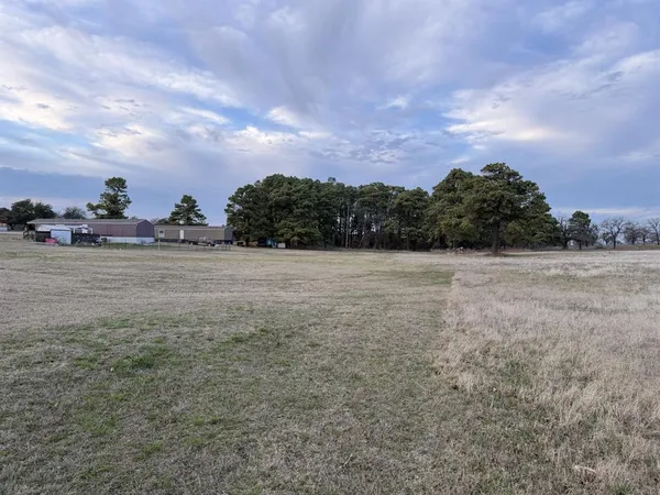 a view of a field with a building in the background