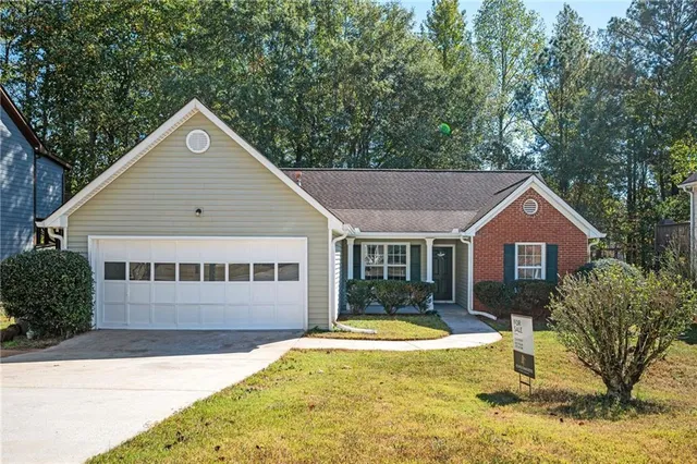 a view of a house with a yard and large tree
