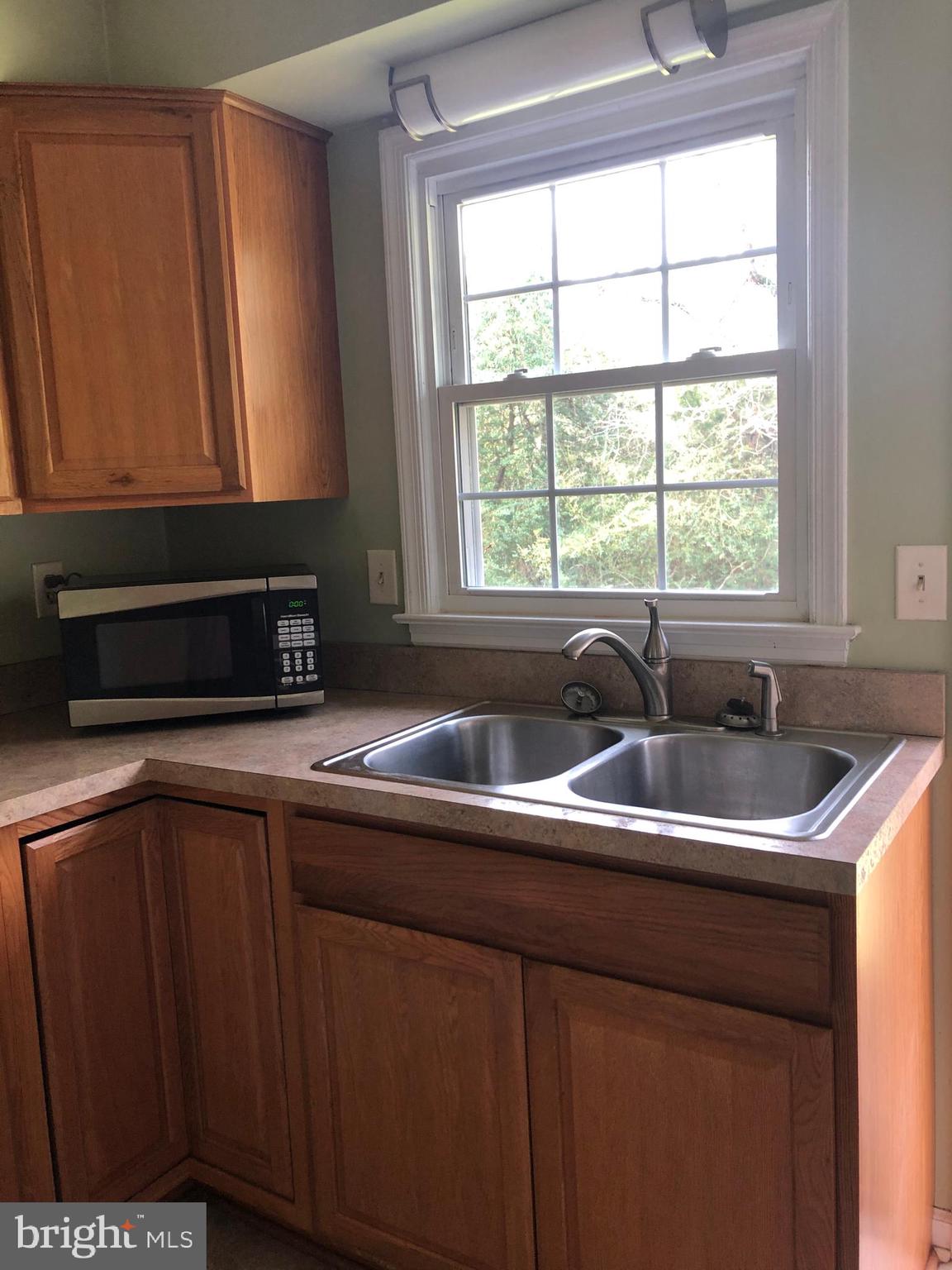 14296 Springfield Lane King George, VA 22485 - Photo 3 of 10 a kitchen with stainless steel appliances granite countertop a sink a microwave cabinets and a window