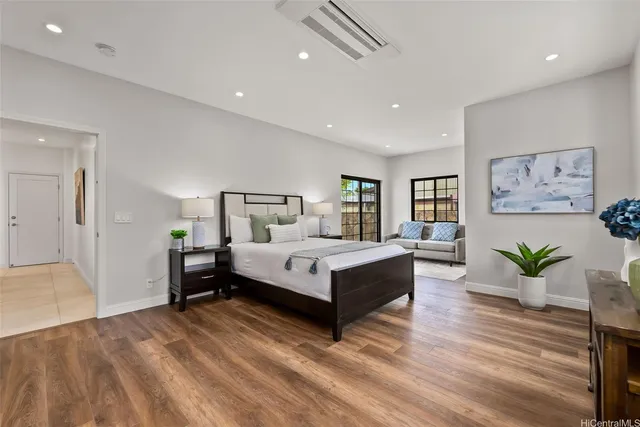 a bedroom with a large bed and paintings on the wall