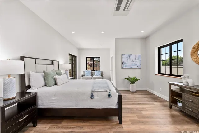 a bedroom with a large bed and wooden floor