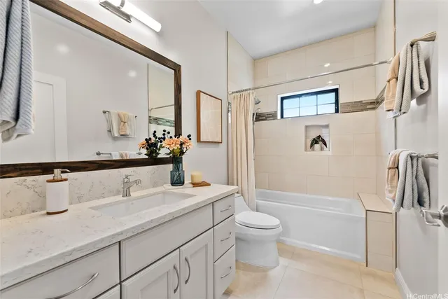 a bathroom with a granite countertop sink a toilet a mirror and shower