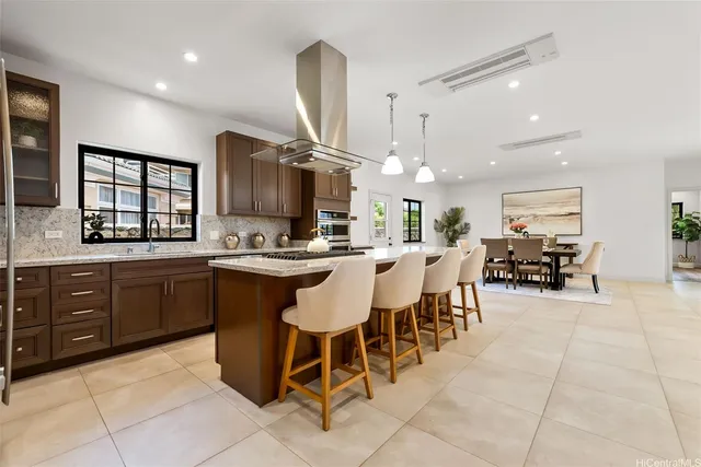 a large kitchen with a large counter space a sink appliances and cabinets
