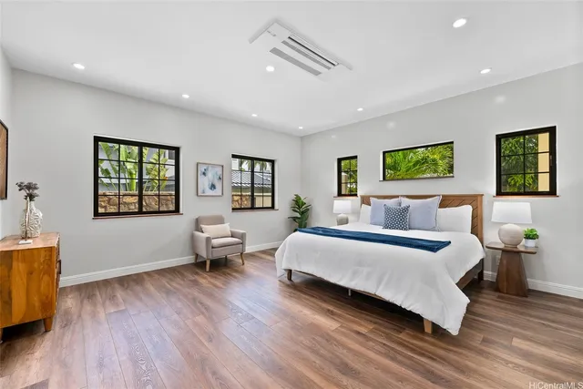 a spacious bedroom with a bed and wooden floor