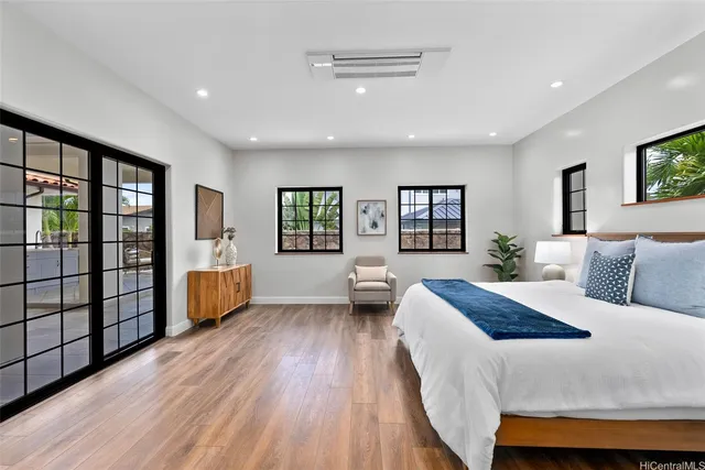 a spacious bedroom with a large bed and a wooden floor